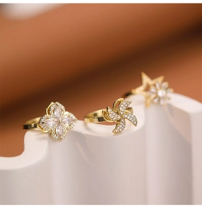 Detailed macro shot of rotating gold rings with star and windmill zircon motifs