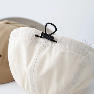 Détail du cordon de serrage élastique et de la boucle sur le béret en coton pour enfant