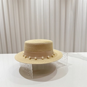 Détail d'un chapeau de paille vintage avec garniture en perles et ruban gros-grain élégant