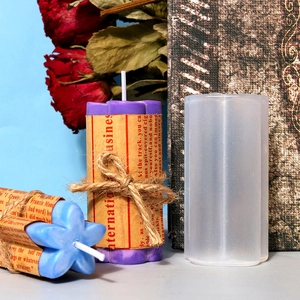 DIY cylindrical silicone candle mold with finished flower top candles on retro books