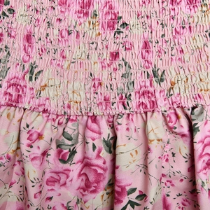 Close-up of pink floral fabric showing shirred elastic texture and soft ruffled layers