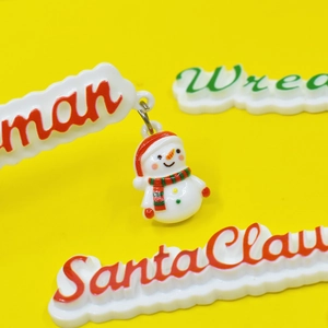 Macro shot of resin Christmas snowman pendant and letter tags for DIY accessories