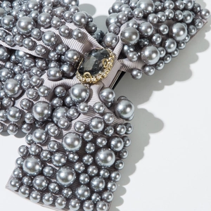 Detail of bridal hair clip with gray pearls and large dark gemstone center focus