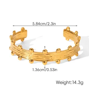 Detail view of gold-plated stainless steel open cuff bracelet with textured grain finish
