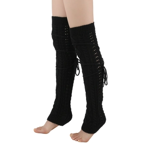 Macro detail of black cable-knit leg warmers featuring stylish side lace-up bow details