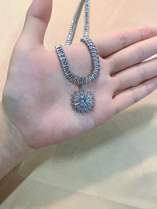 Close-up of sparkling rhinestone necklace with a large sunflower pendant on silk