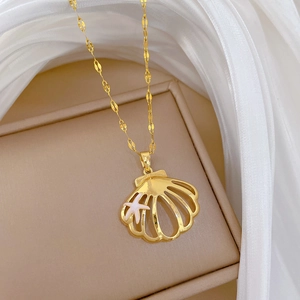 Detailed close-up of golden shell pendant necklace with starfish on jewelry box
