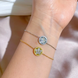 Star-shaped rhinestone pendant bracelet in gold and silver on silk background