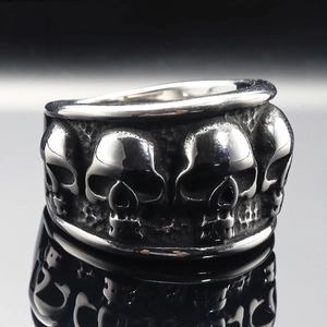 Dettaglio ravvicinato di un anello in acciaio vintage con rilievi gotici di teschi 3D
