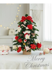 Close-up of mini green flocked Christmas tree with red bow, felt ornaments, and warm LED lights