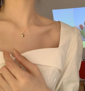 Elegant gold heart pendant necklace displayed on a model's neck for a stylish look