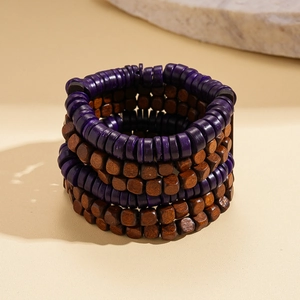 Dettaglio del bracciale etnico multistrato di perline di cocco viola e marroni