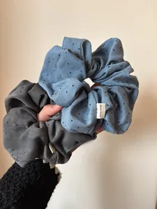 Close-up of blue and grey polka dot scrunchies with Hand Made label detail