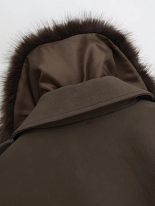 Detailed close-up of dark brown faux leather jacket texture and plush fur collar detail