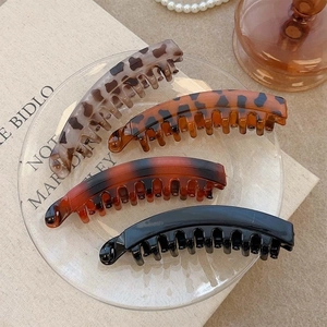 Set of 4 vintage banana hair clips in leopard, tortoiseshell, and black on glass tray