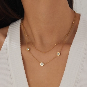 Detail of double-layer gold stainless steel necklace with rhinestones on a model
