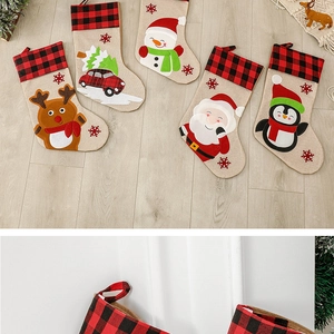 Detailed view of linen Christmas stockings with red plaid cuffs and applique embroidery