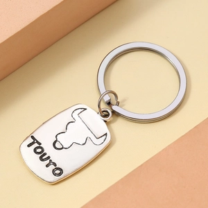 Close-up of a silver zodiac keychain featuring a Taurus bull relief and lettering