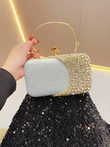 Macro shot of silver and gold evening bag with rhinestones and metal ring handle