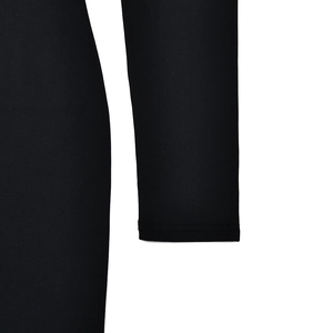 Detailed close-up of smooth elastic fabric and stitching on black long sleeve dress