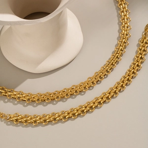 Macro view of golden butterfly chain link jewelry with polished texture and weave detail