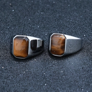 Detailed macro view of square brown tiger eye stone on polished stainless steel ring