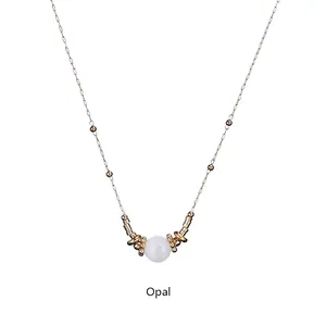 Detail view of gold stainless steel necklace featuring a round white opal stone pendant