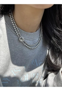 Macro shot of double-layer grey glass pearl necklace with silver square zircon pendant