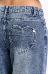 Detailed view of vintage washed blue jeans featuring heart-shaped back pockets and rivets