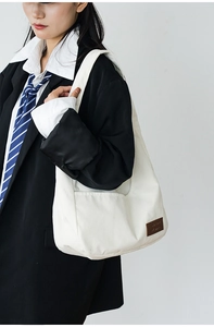 Detailed texture of white corduroy shoulder bag styled with an elegant blazer outfit
