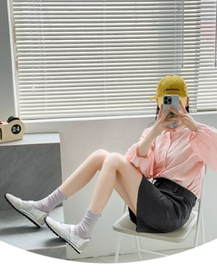 Close-up of stylish white ruffled socks worn with silver loafers and a black mini skirt