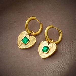 French vintage gold heart earrings with emerald green zircon on silk background