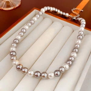 Detailed view of dual-color white and grey pearl necklace in a premium jewelry gift box