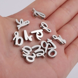 Macro shot of silver cursive metal alphabet beads for DIY jewelry with small holes