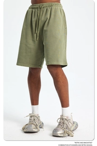 Close-up of olive green knit cotton sports shorts with retro acid wash texture detail