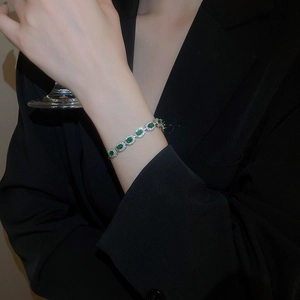 Détail du bracelet en argent avec pierres vertes ovales et halo de zircon sur mannequin