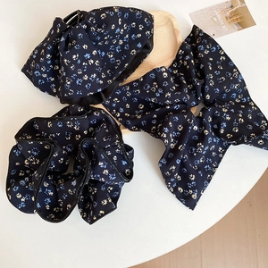Detail of floral fabric hair accessory set including scrunchie, headband and bow tie