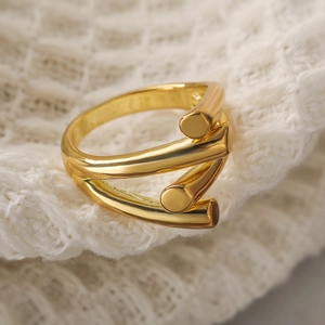 Minimalist irregular geometric layered ring in shiny gold metal on white knit fabric