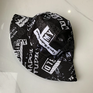 Close-up of black and white newsprint pattern on cotton bucket hat with graphic text