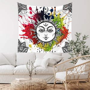 Bohemian sun tapestry hanging above a white sofa in a minimalist living room setting