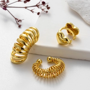 Polished gold cartilage ear cuffs featuring spiral, textured, and heart designs