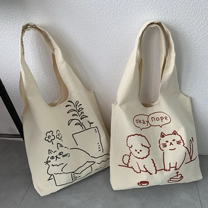 Detail of cream canvas tote bags with cute cat and dog illustrations for daily use