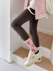 Detailed shot of pink heart-patterned socks paired with dark grey leggings on steps