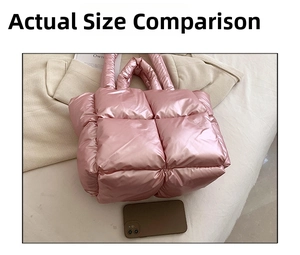 Detailed view of pink metallic quilted puffy tote bag on a white textured surface