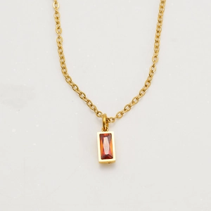 Detail shot of rectangular red birthstone pendant on a gold stainless steel chain