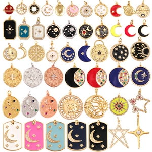Detail of celestial enamel pendants featuring moon and star motifs in mixed metal finishes