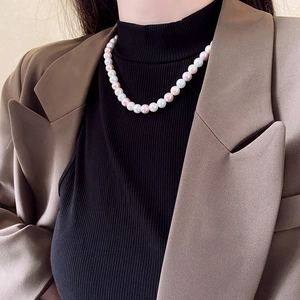 Detailed close-up of a premium pearl necklace featuring white and lavender pink pearls