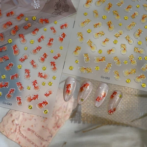 Detailed view of 3D goldfish nail art stickers with embossed texture and gold accents