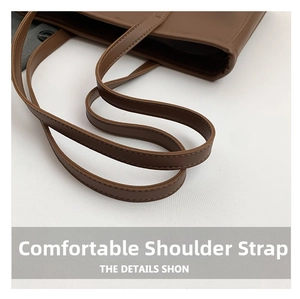 Close-up of brown tote bag shoulder strap with neat stitching and durable faux leather