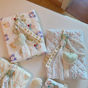 Detail of quilted cotton pouches with lace edges, pearls, and cute floral patterns